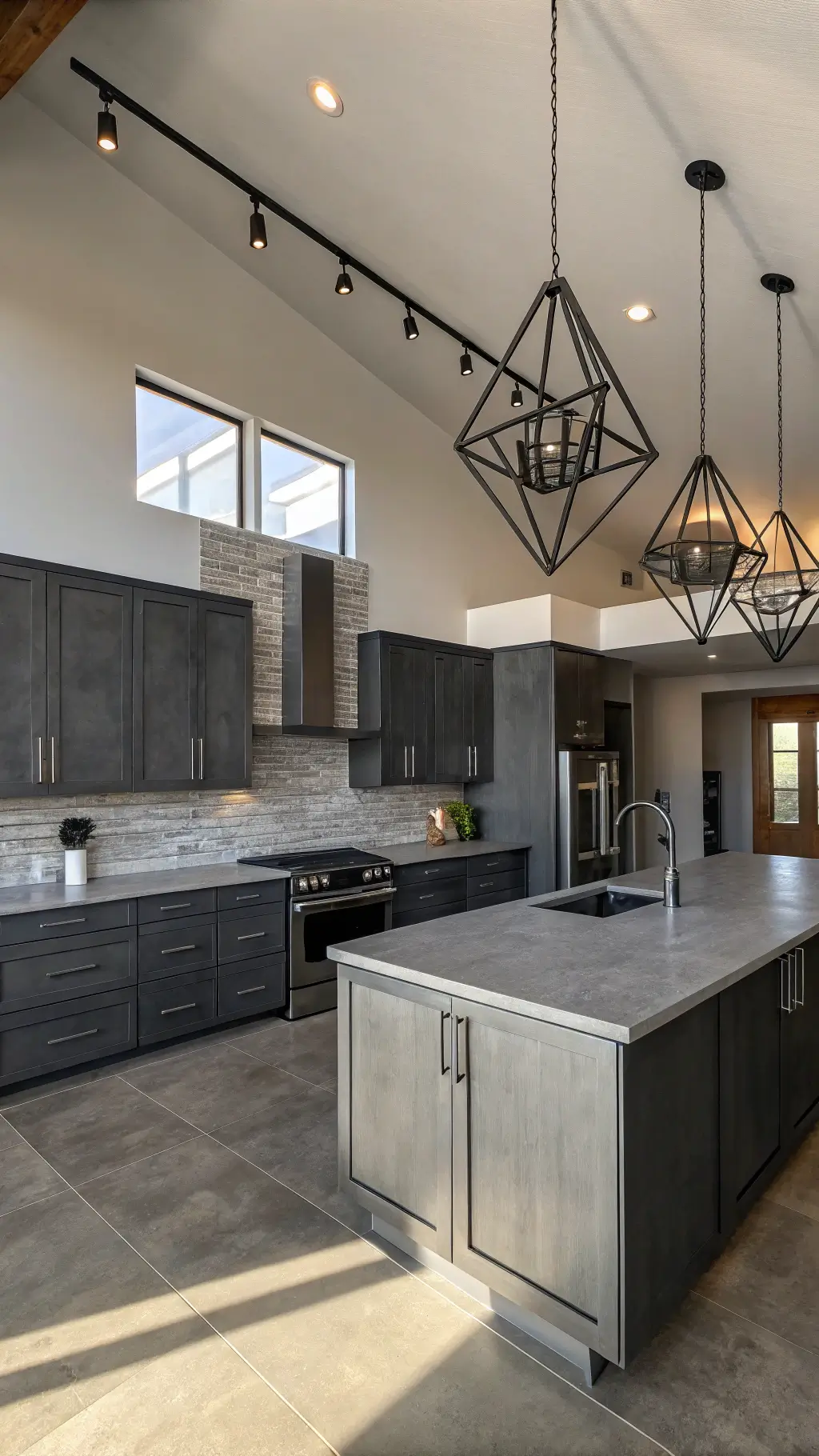 Modern L-shaped kitchen with charcoal gray cabinets, brushed steel appliances, concrete countertops, and geometric pendant lights, shot from above the island.